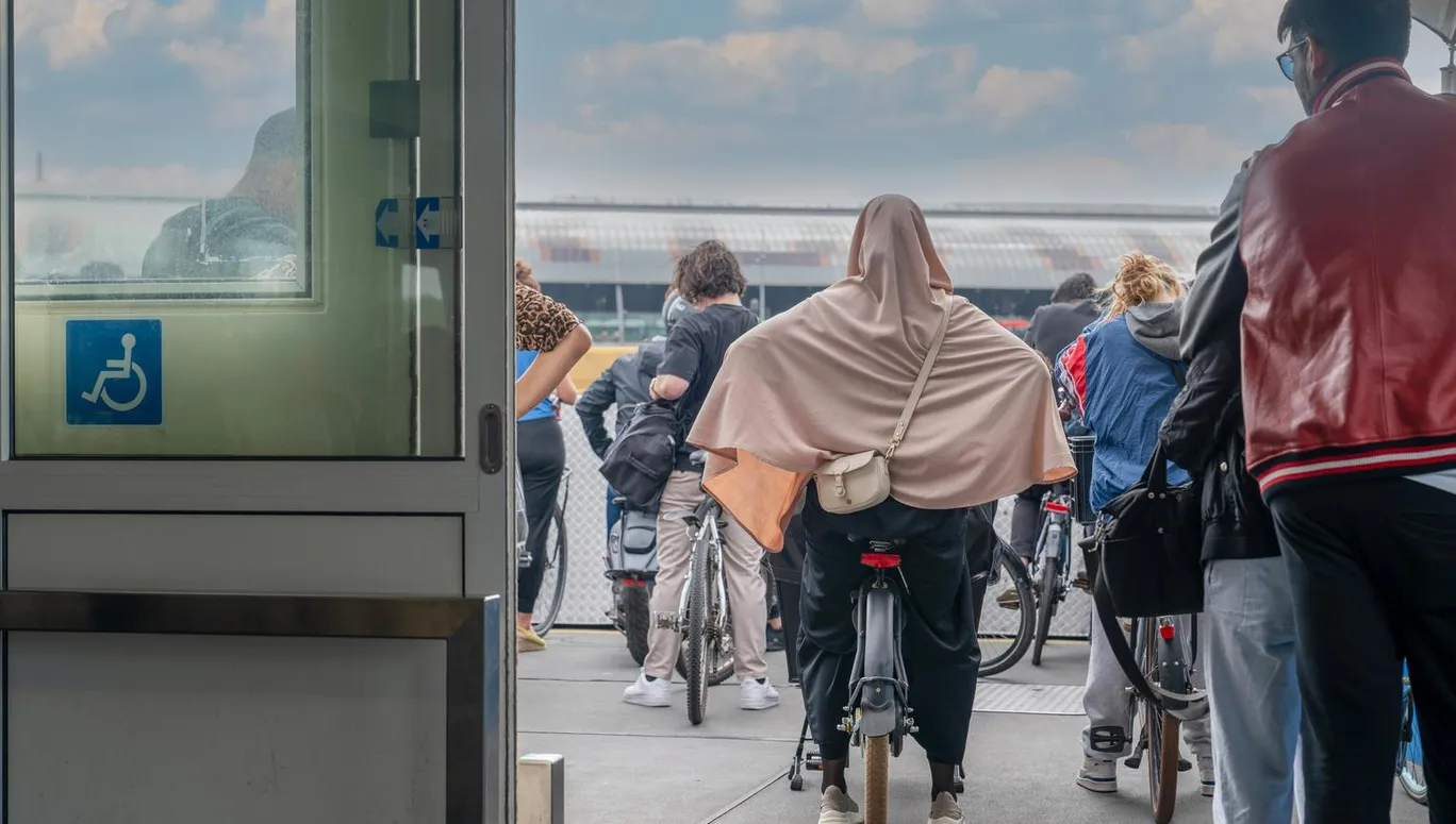 Back rear view of cyclists waiting on the boat heading towards the central station
