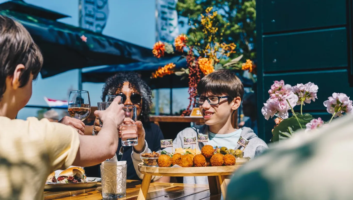 People making a toast with borrelplank and bitterballen at Theehuis Cruquius.