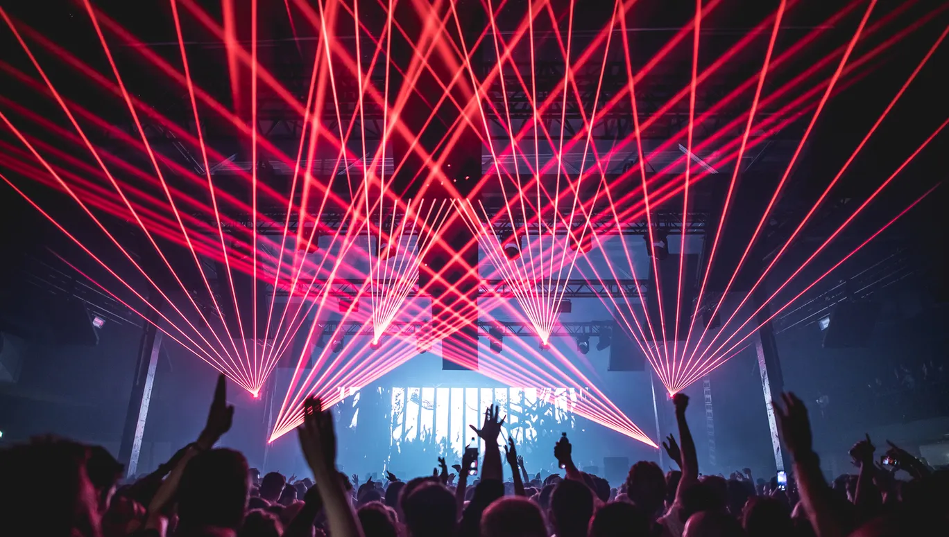 People dancing under the red laserlights.