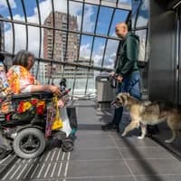 A person in an electric wheelchair on the metro platform waiting before entering the elevator in Noord.