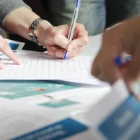 Close-up of hands going through stacks of forms