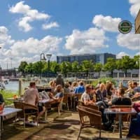 People sitting on the terrace of Pension Homeland at the Marineterrein