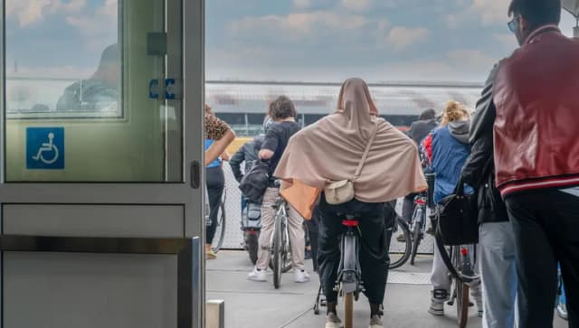 Back rear view of cyclists waiting on the boat heading towards the central station