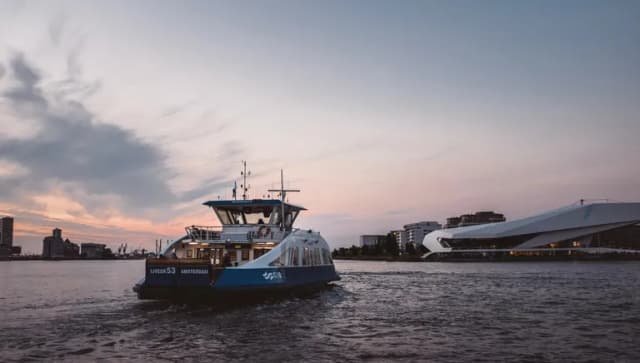 A ferry on its way to Buiksloterweg and EYE Promenade with the Eye Filmmuseum in Noord.