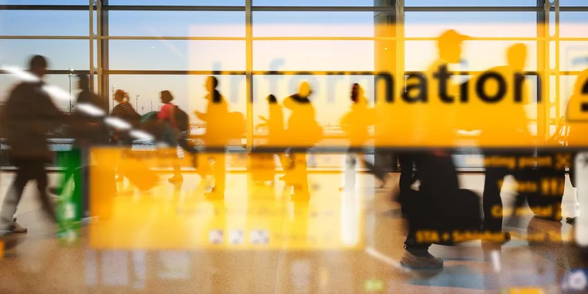 Schiphol airport information sign seen through glass window.