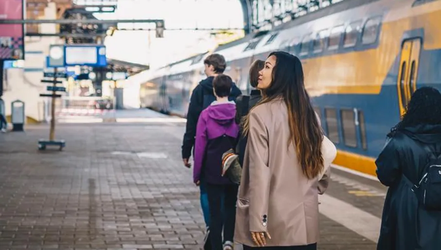 People walk on the platform towards their train
