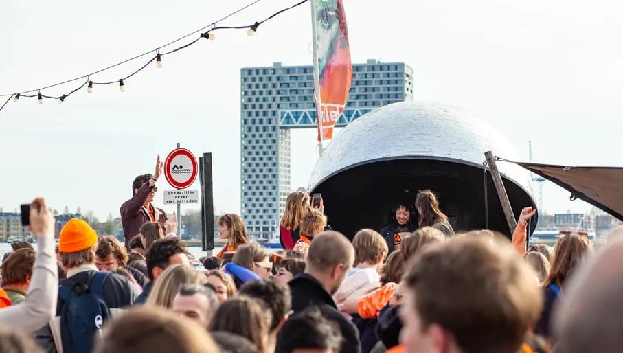 Party people outside at Pllek beach on King's Day