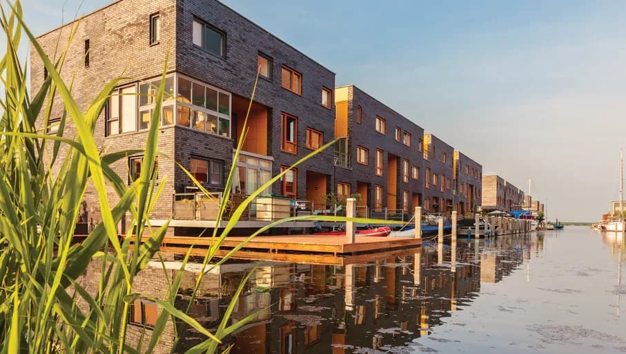 Row of Dutch modern canal houses in Almere reflected in the water