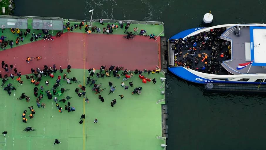 Koningsdag or King's Day People getting into a ferry.
Celebrations: Partying, wearing orange costumes, and traditional local gatherings.