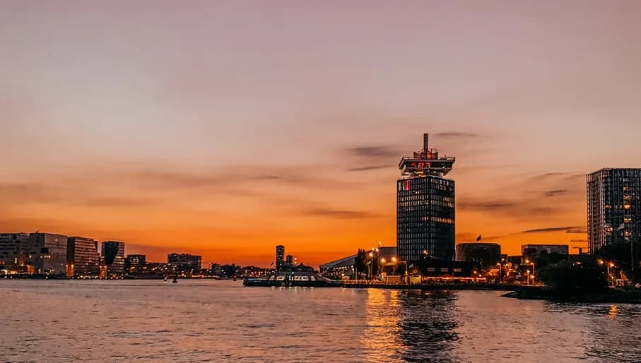 The A'DAM Tower and 't IJ at nightfall.