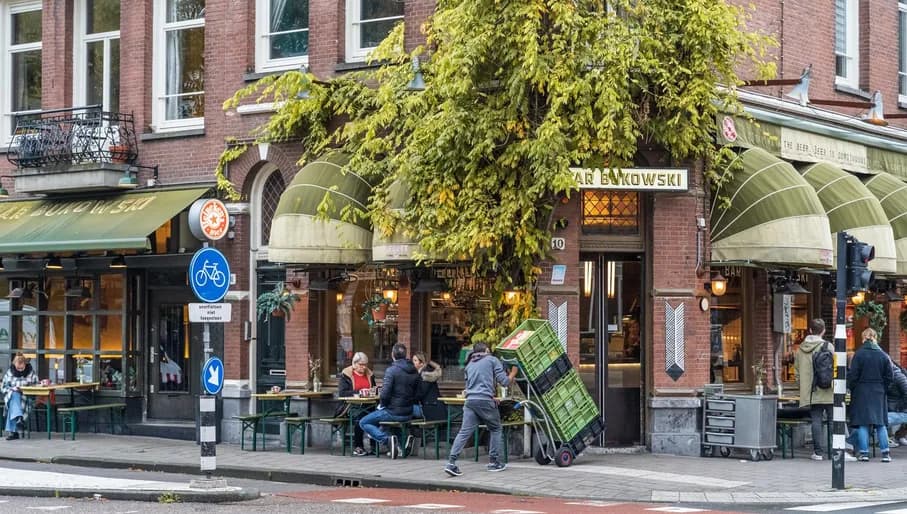 People sitting outside on the terrace from Bar Bukowski at Beukenplein, Amsterdam-Oost.